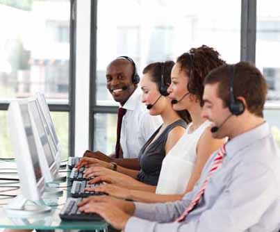 telemarketers sit at a desk, on the phone with clients